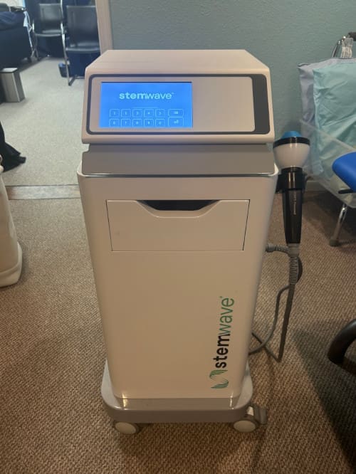 A white LaserPro medical device on carpeted floor with a blue display.